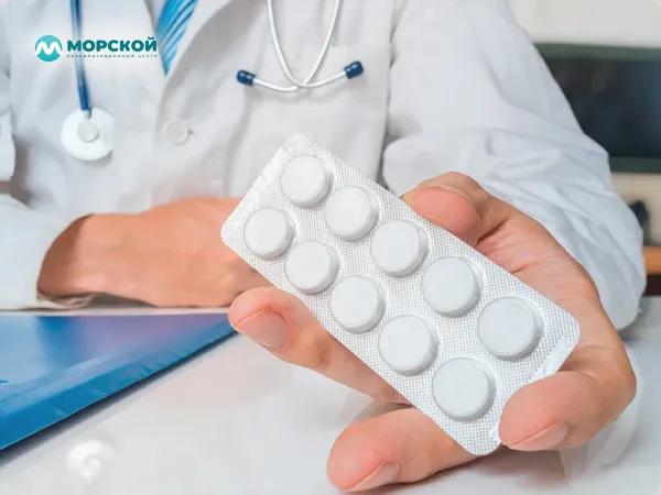 Врач показывает таблетки Врач предлагаtт пластинку с таблетками